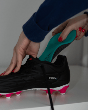 Fußball Einlage wird in Fußballschuh eingesetzt